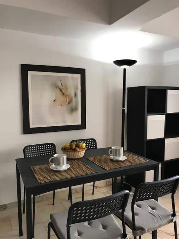 Contemporary dining area with black table and chairs in luxury Malaga Apartment.