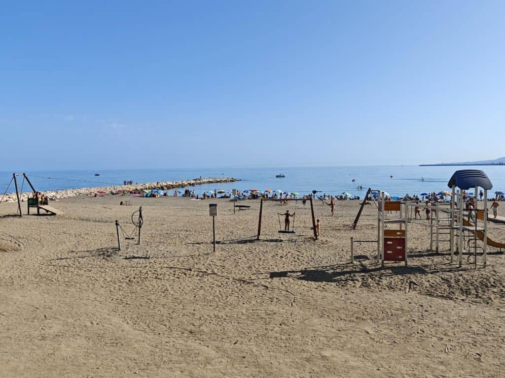 acaleta beach in málaga with a group of people and a body of water