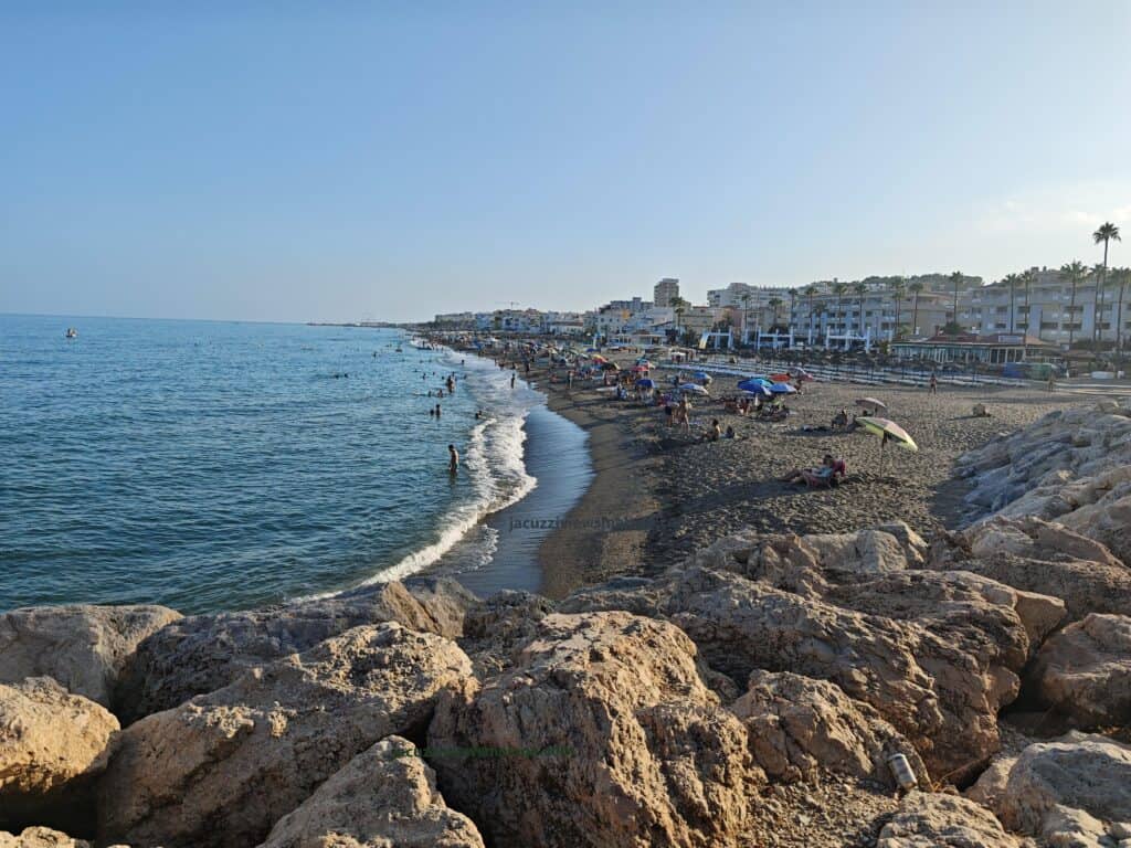 a beach with many people and rocks